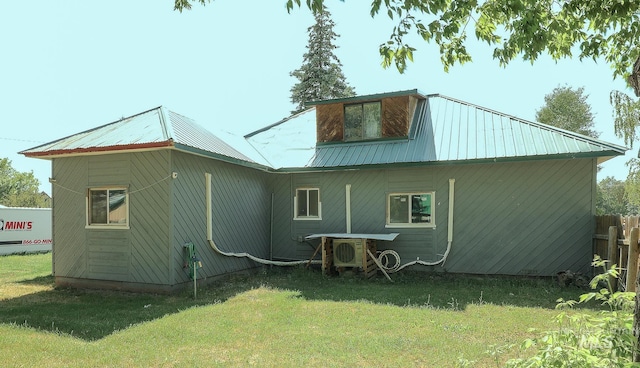 rear view of property featuring metal roof, a yard, and ac unit