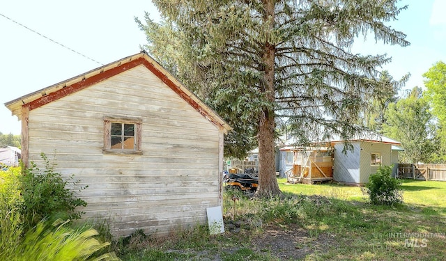 view of property exterior with an outbuilding and fence