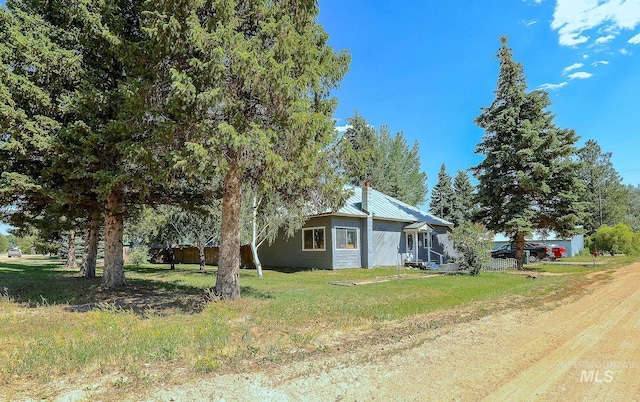 exterior space with metal roof and a yard