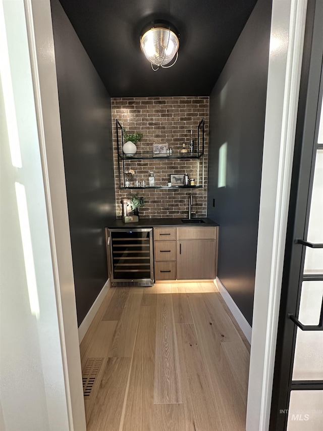 461 S Quincannon Ln, Star, ID 83669 - bar with wine cooler, baseboards, indoor wet bar, light wood-type flooring, and a sink