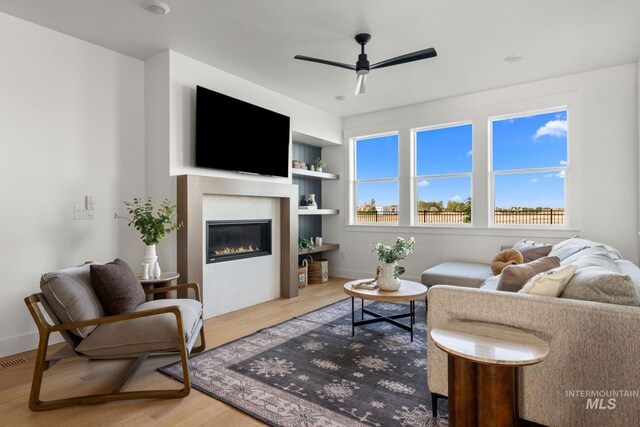 461 S Quincannon Ln, Star, ID 83669 - living area featuring a ceiling fan, built in shelves, wood finished floors, baseboards, and a glass covered fireplace