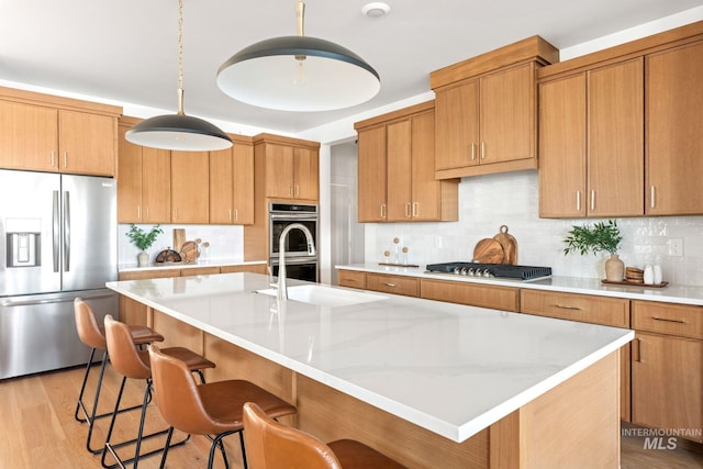 461 S Quincannon Ln, Star, ID 83669 - kitchen with a center island with sink, tasteful backsplash, stainless steel appliances, and a kitchen breakfast bar