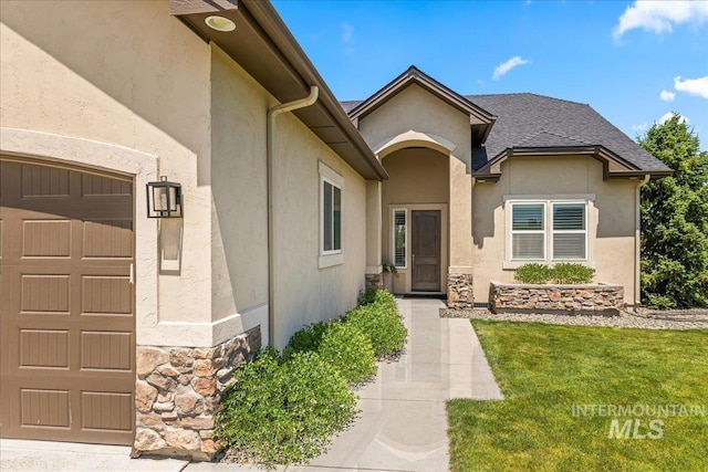 9968 Moon Shadow Ct, Middleton, ID 83644 - view of exterior entry with stone siding, stucco siding, a yard, and roof with shingles