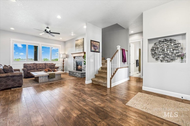9968 Moon Shadow Ct, Middleton, ID 83644 - living area with wood-type flooring, a stone fireplace, ceiling fan, stairway, and a textured ceiling