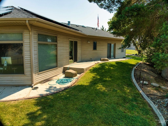 back of property featuring a patio and a yard