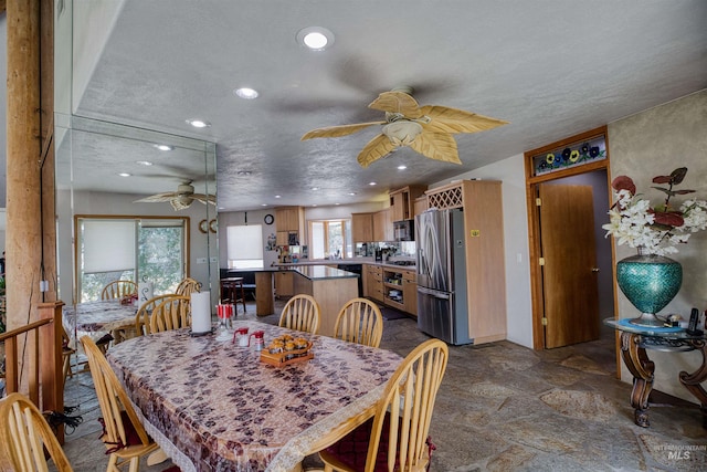 tiled dining room with a textured ceiling and ceiling fan