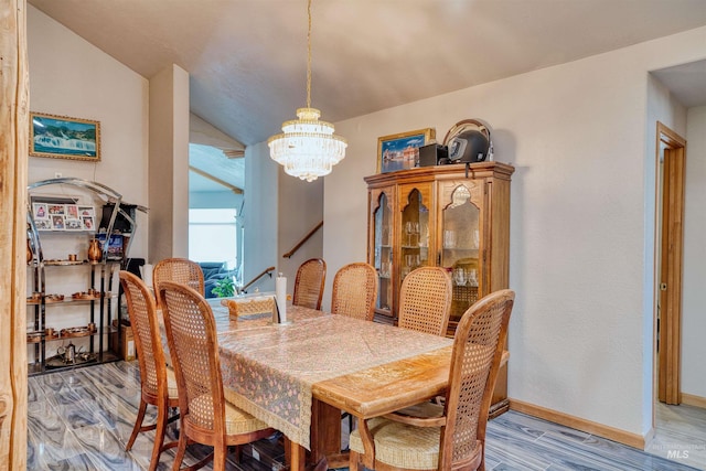 dining room with light hardwood / wood-style floors, an inviting chandelier, and lofted ceiling