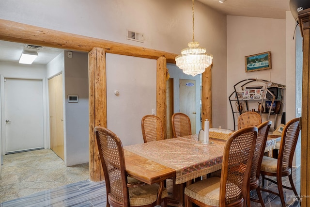 dining room featuring a notable chandelier, tile patterned flooring, and vaulted ceiling