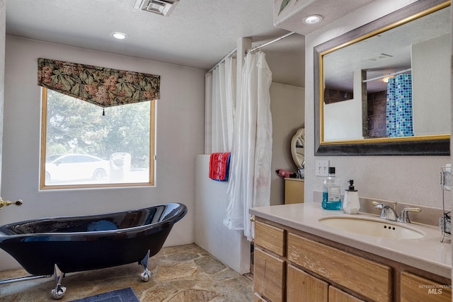 bathroom featuring vanity, tile patterned floors, and a textured ceiling