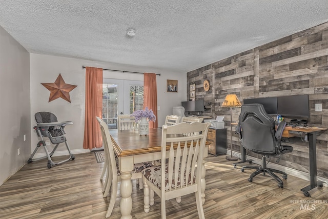 455 Farber Dr, Payette, ID 83661 - dining area featuring a textured ceiling, french doors, an accent wall, and wood finished floors