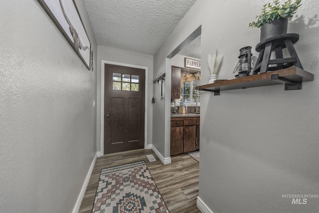 455 Farber Dr, Payette, ID 83661 - doorway to outside featuring a textured ceiling, baseboards, and wood finished floors