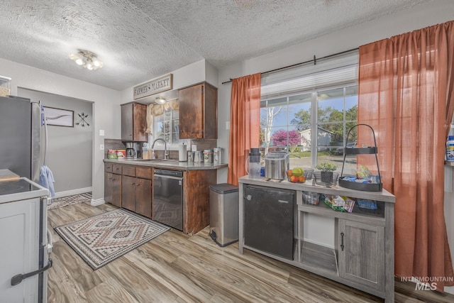455 Farber Dr, Payette, ID 83661 - kitchen featuring a textured ceiling, appliances with stainless steel finishes, a sink, baseboards, and light wood-style floors