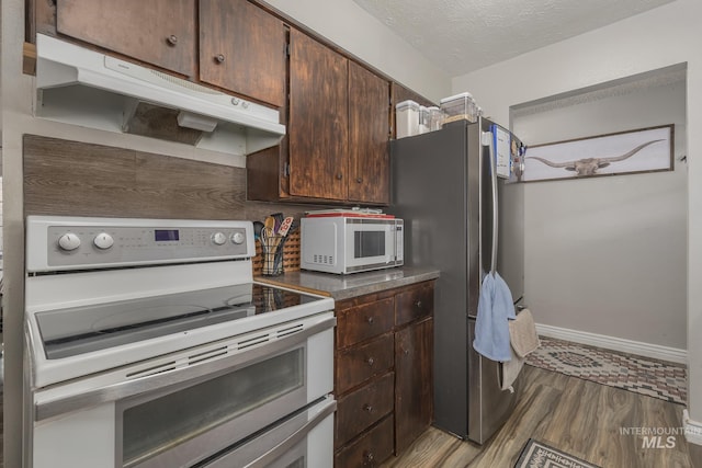 455 Farber Dr, Payette, ID 83661 - kitchen with dark brown cabinetry, baseboards, light wood finished floors, under cabinet range hood, and white appliances