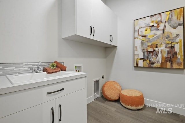 9382 Basin Kid, Middleton, ID 83644 - laundry area featuring hookup for a washing machine, wood finished floors, a sink, hookup for an electric dryer, and cabinet space