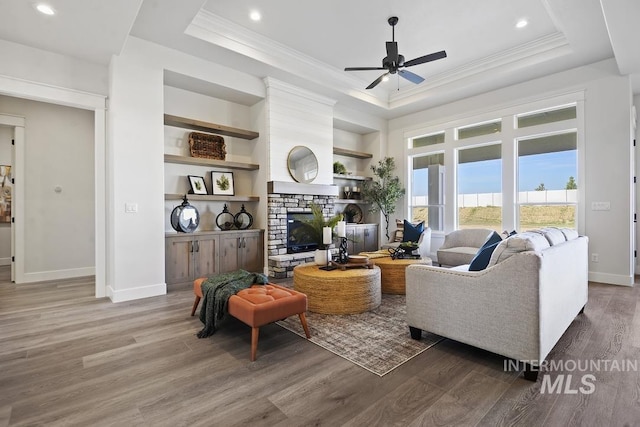 9382 Basin Kid, Middleton, ID 83644 - living room featuring a tray ceiling, wood finished floors, a fireplace, and a ceiling fan