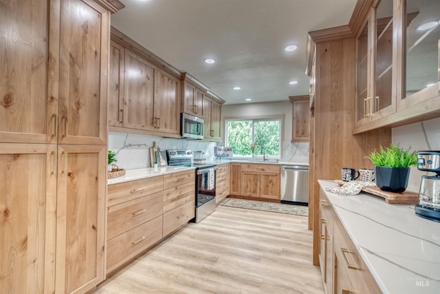 3131 Fuller Rd, Emmett, ID 83617 - kitchen featuring appliances with stainless steel finishes, light wood-style floors, backsplash, recessed lighting, and glass insert cabinets
