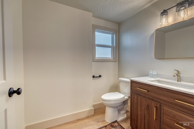 3131 Fuller Rd, Emmett, ID 83617 - half bathroom with wood finished floors, toilet, vanity, a textured ceiling, and baseboards