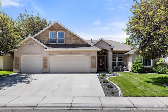 3011 S Montego Way, Nampa, ID 83686 - view of front of home with stucco siding, an attached garage, driveway, a front yard, and stone siding