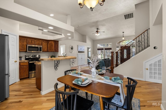 3011 S Montego Way, Nampa, ID 83686 - dining area with light wood-style floors, a ceiling fan, lofted ceiling, recessed lighting, and stairs