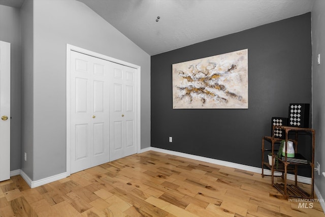 3011 S Montego Way, Nampa, ID 83686 - unfurnished bedroom with light wood-type flooring, lofted ceiling, baseboards, and a closet