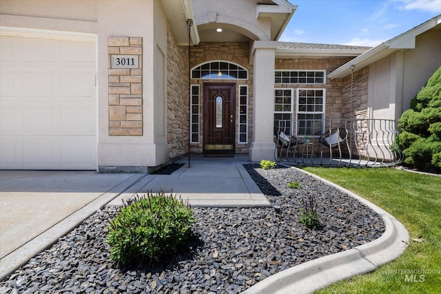 3011 S Montego Way, Nampa, ID 83686 - entrance to property with stone siding, an attached garage, driveway, and stucco siding