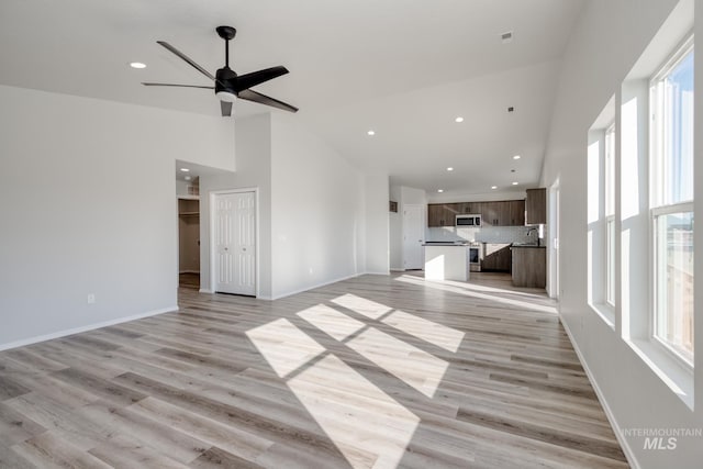 1457 W Bass River Dr, Meridian, ID 83642 - unfurnished living room with plenty of natural light, high vaulted ceiling, a sink, recessed lighting, and light wood finished floors