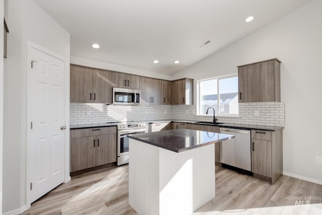 1457 W Bass River Dr, Meridian, ID 83642 - kitchen with stainless steel appliances, a sink, dark countertops, backsplash, and lofted ceiling