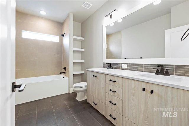 full bathroom with toilet, tiled shower / bath, vanity, tile patterned flooring, and backsplash