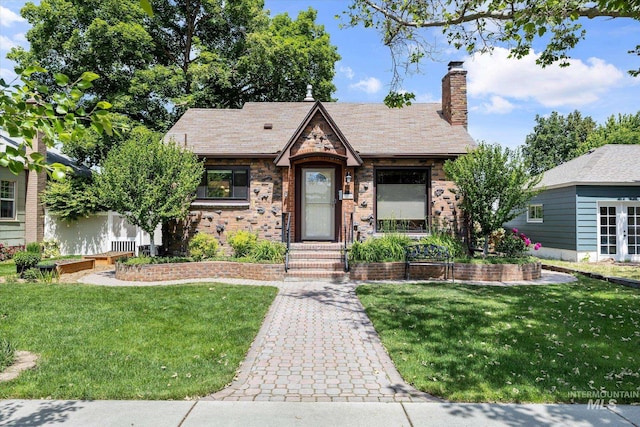 2316 W Madison Ave, Boise, ID 83702 - tudor house featuring a front yard, a chimney, and brick siding
