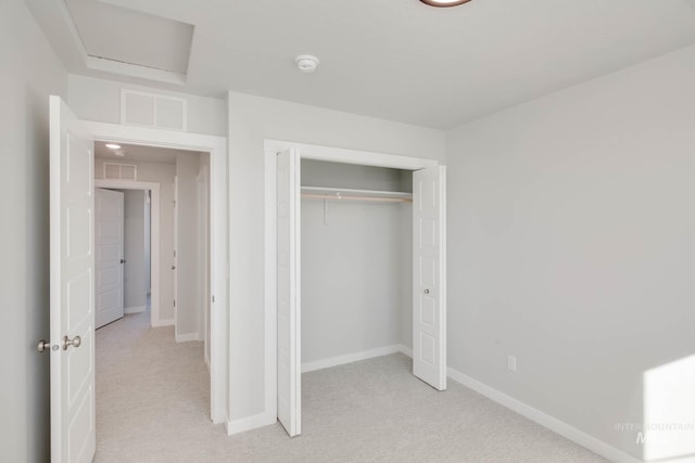 unfurnished bedroom featuring light colored carpet and a closet