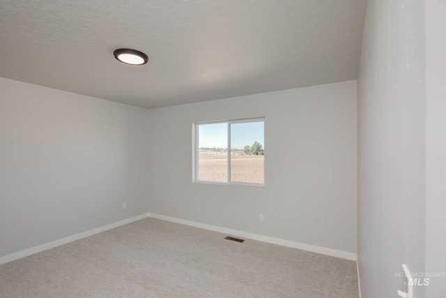 carpeted spare room featuring a textured ceiling