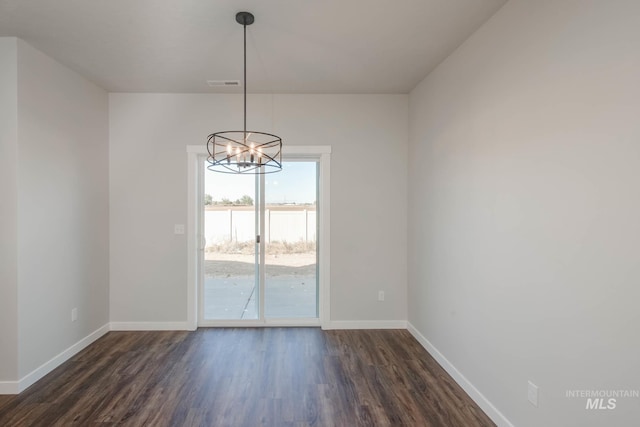 unfurnished dining area with dark hardwood / wood-style floors and an inviting chandelier