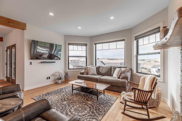 living area featuring recessed lighting, light wood-style flooring, baseboards, and a healthy amount of sunlight