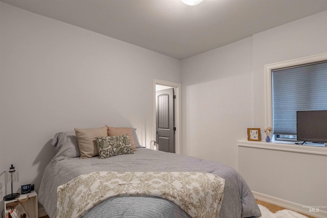 bedroom featuring baseboards and wood finished floors