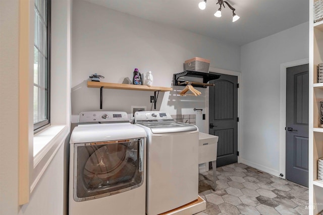laundry area featuring baseboards, light floors, washer and dryer, and laundry area