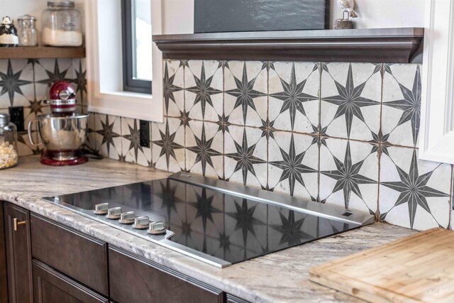 room details featuring tasteful backsplash, dark brown cabinets, and black electric cooktop