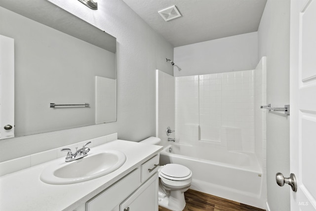 full bathroom with visible vents, toilet, wood finished floors, bathtub / shower combination, and vanity