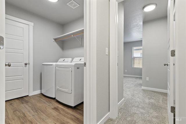 laundry area with laundry area, baseboards, visible vents, and washer and clothes dryer