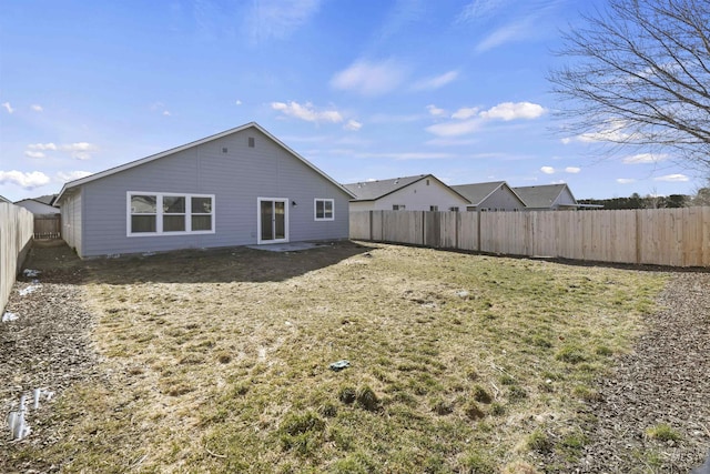 back of property featuring a yard and a fenced backyard