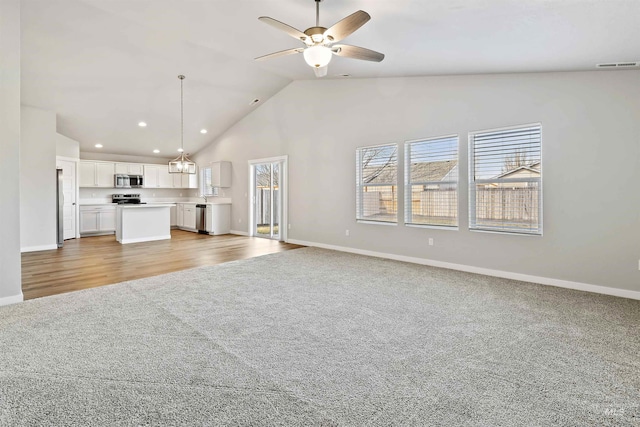 unfurnished living room with visible vents, light colored carpet, baseboards, and a ceiling fan