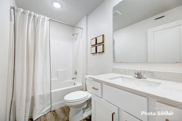 bathroom featuring wood finished floors, toilet, vanity, and shower / tub combo with curtain