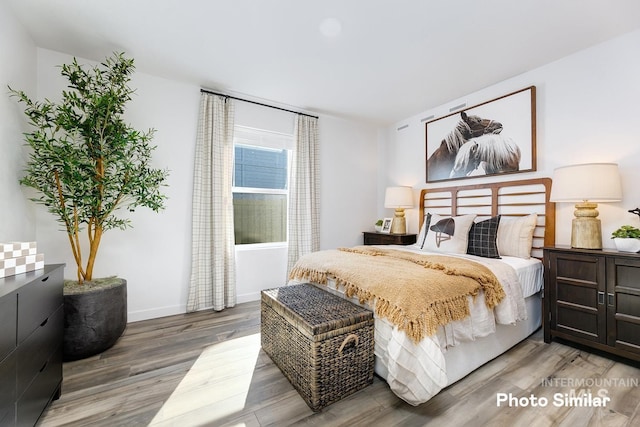 bedroom featuring wood finished floors and baseboards