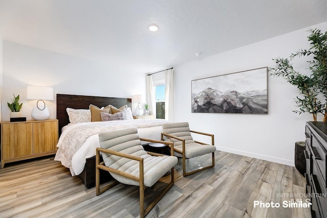 bedroom with light wood-style floors and baseboards