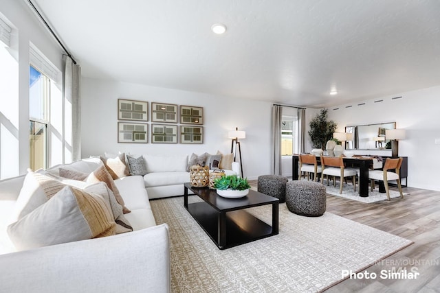 living room with wood finished floors, baseboards, and recessed lighting