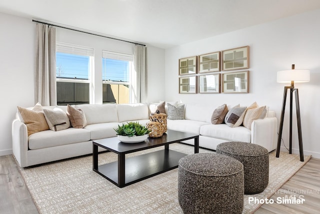 living area featuring light wood-style floors and baseboards