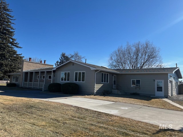 single story home with a sunroom and a front lawn