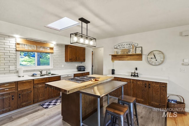 114 Par Dr, Cascade, ID 83611 - kitchen with wooden counters, a skylight, a sink, light wood-style floors, and decorative backsplash