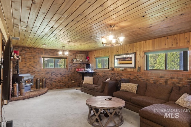 114 Par Dr, Cascade, ID 83611 - carpeted living area featuring brick wall, a wood stove, a chandelier, and wood ceiling