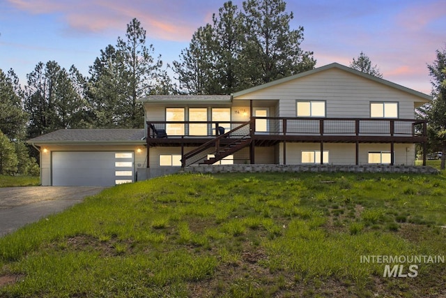 114 Par Dr, Cascade, ID 83611 - view of front facade with concrete driveway, stairs, an attached garage, and a wooden deck