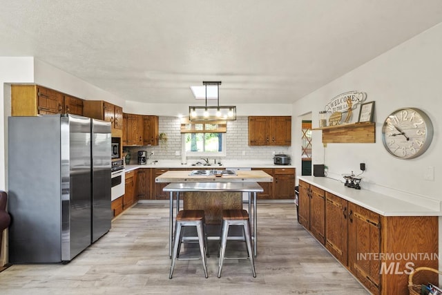 114 Par Dr, Cascade, ID 83611 - kitchen with white appliances, light wood-style flooring, tasteful backsplash, a center island, and light countertops